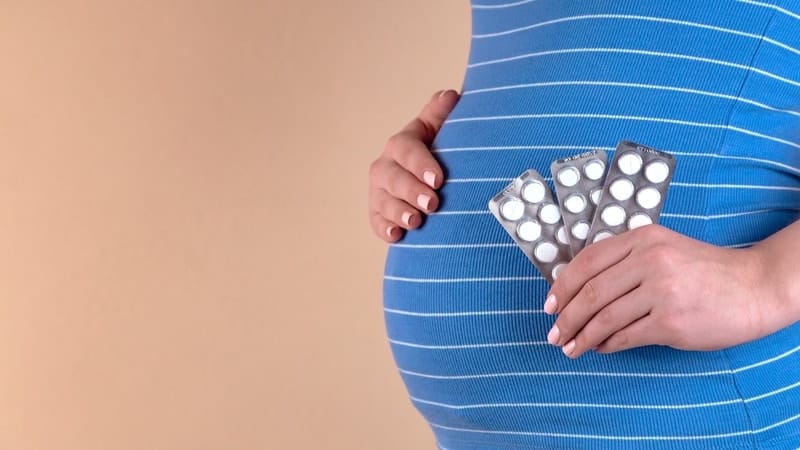 Pregnant Woman Holding Tablets